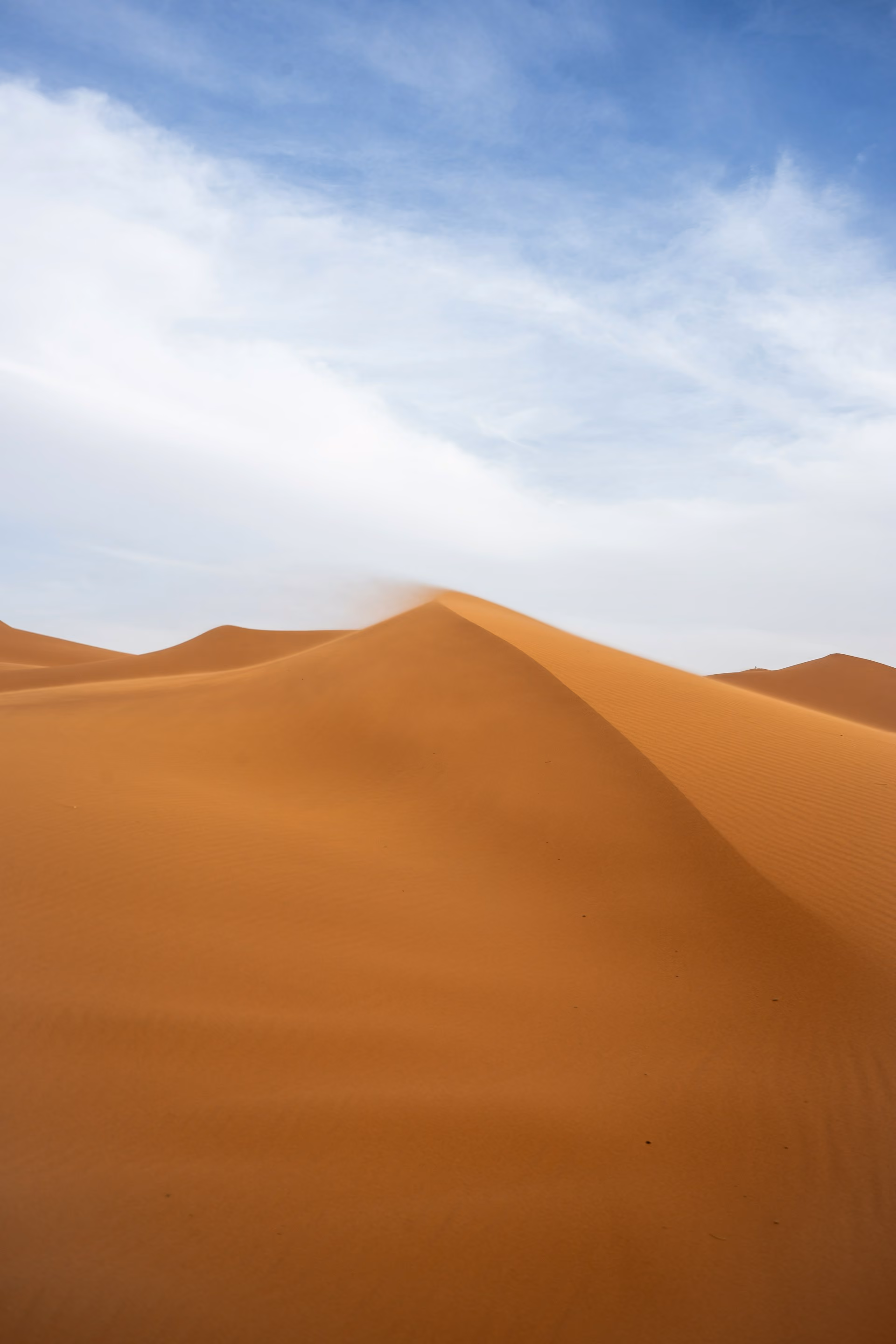 Grande dune de sable sous un ciel bleu